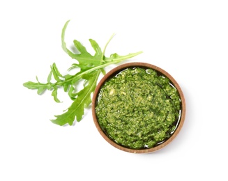 Photo of Bowl of tasty pesto and arugula on white background, top view