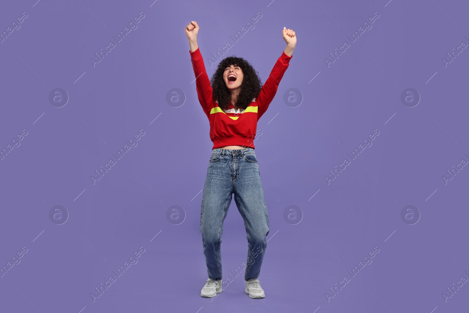 Photo of Happy sports fan celebrating on violet background