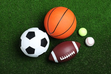 Set of different sport balls on green grass, flat lay