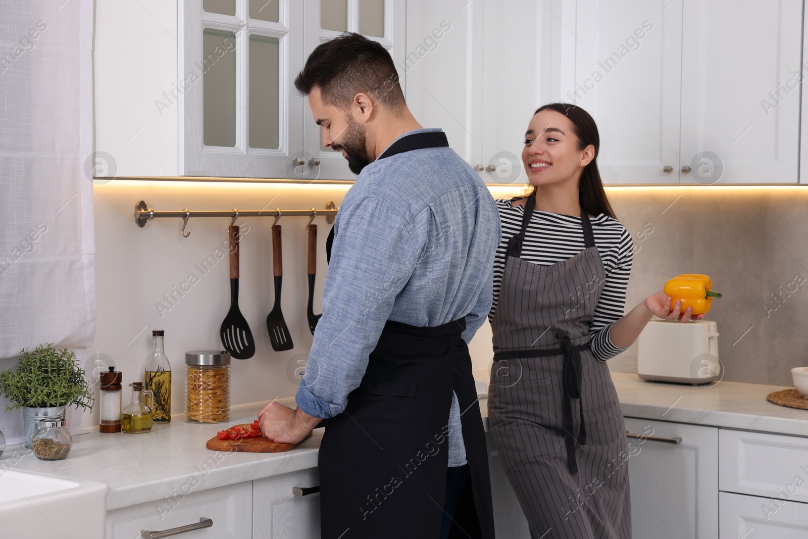 Photo of Happy lovely couple cooking together in kitchen