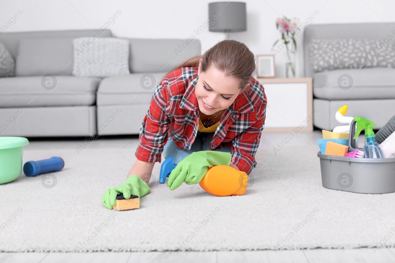 Photo of Woman cleaning carpet in living room