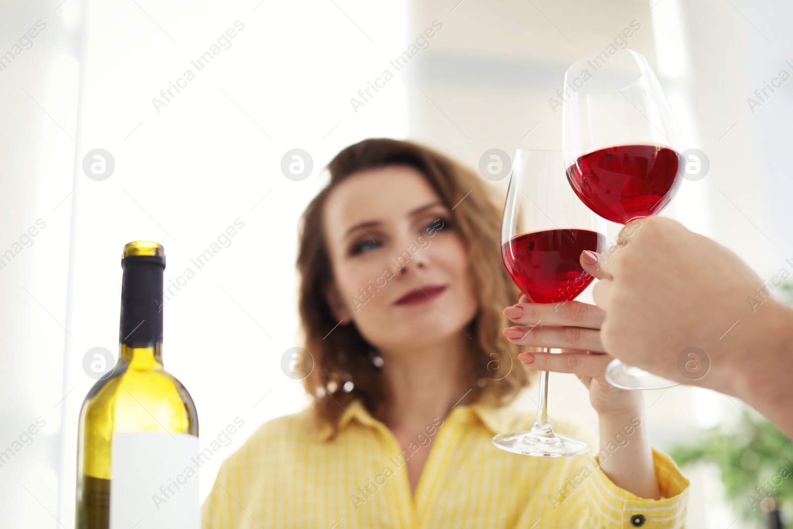 Photo of Young couple with glasses of delicious wine indoors