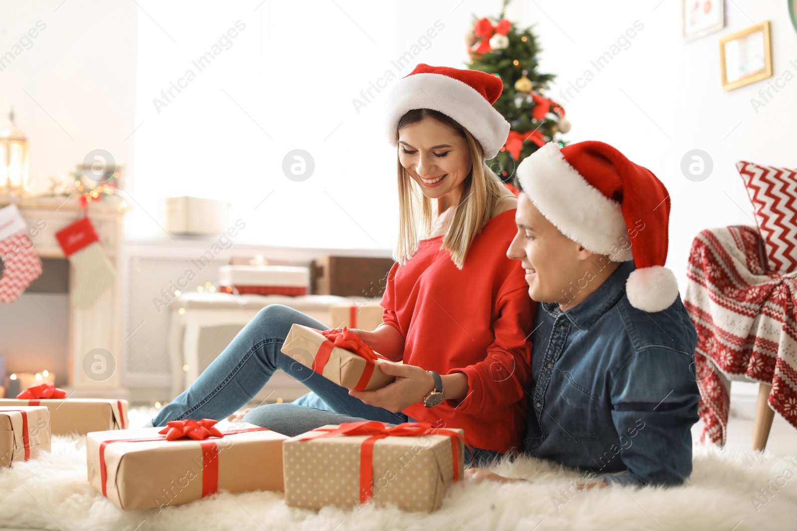 Photo of Young couple with Christmas gifts at home