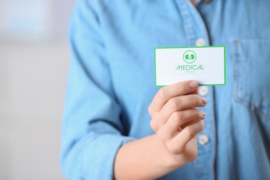 Photo of Woman holding medical business card on blurred background, closeup with space for text. Nephrology service