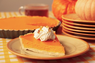 Photo of Piece of fresh homemade pumpkin pie with whipped cream on table