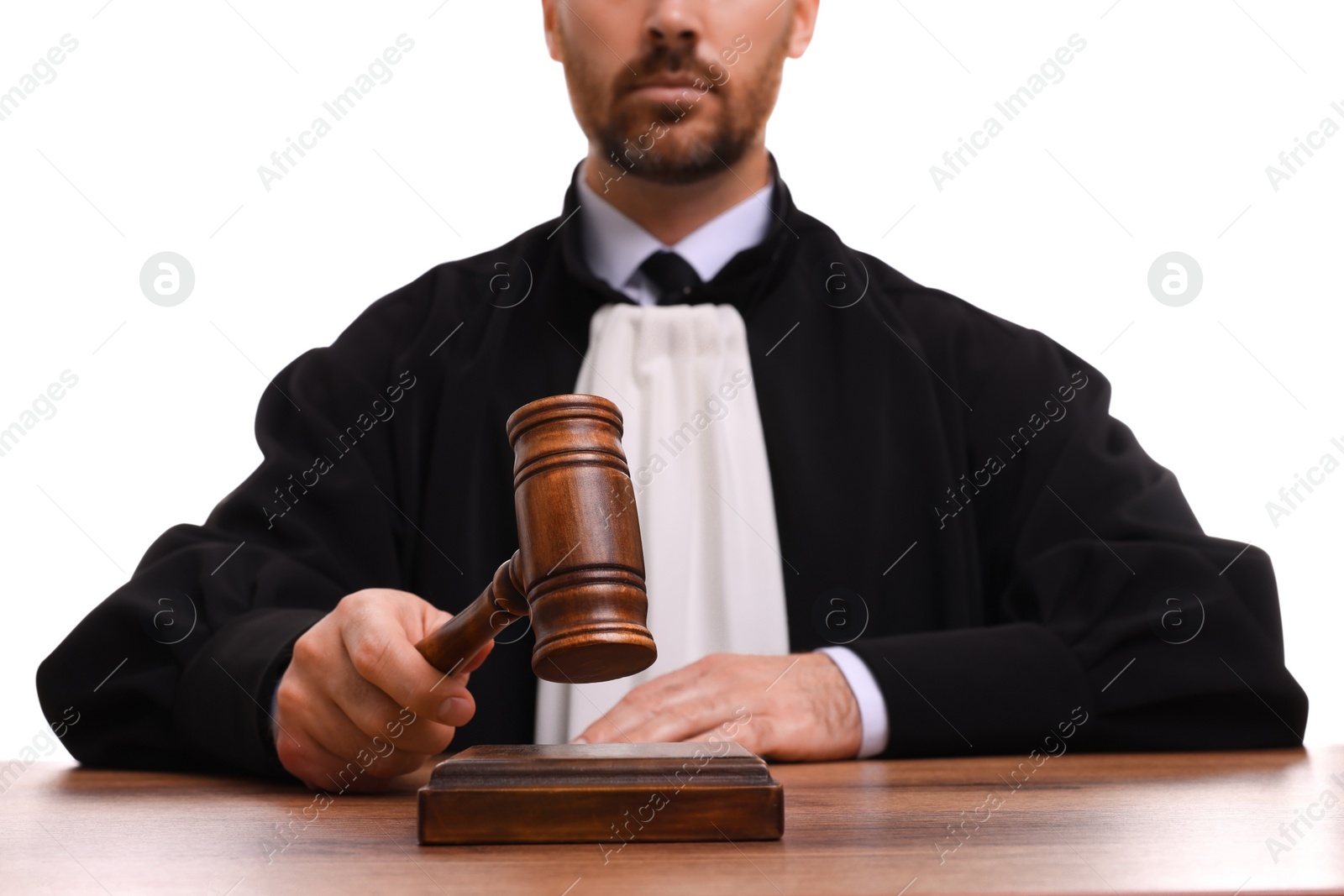 Photo of Judge with gavel at wooden table on white background, closeup