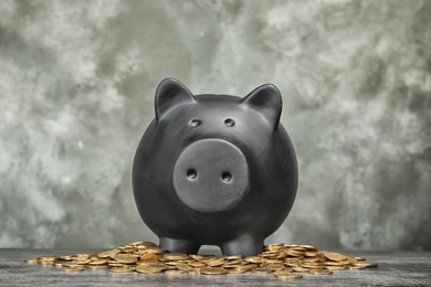 Photo of Black piggy bank and coins on table