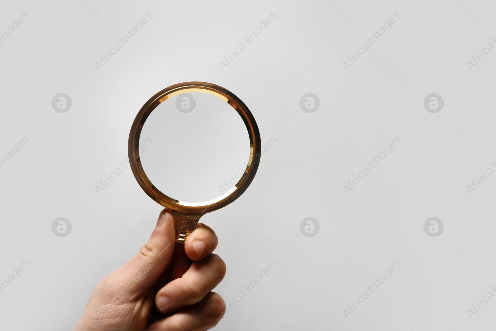 Photo of Woman holding magnifying glass on white background, closeup. Space for text