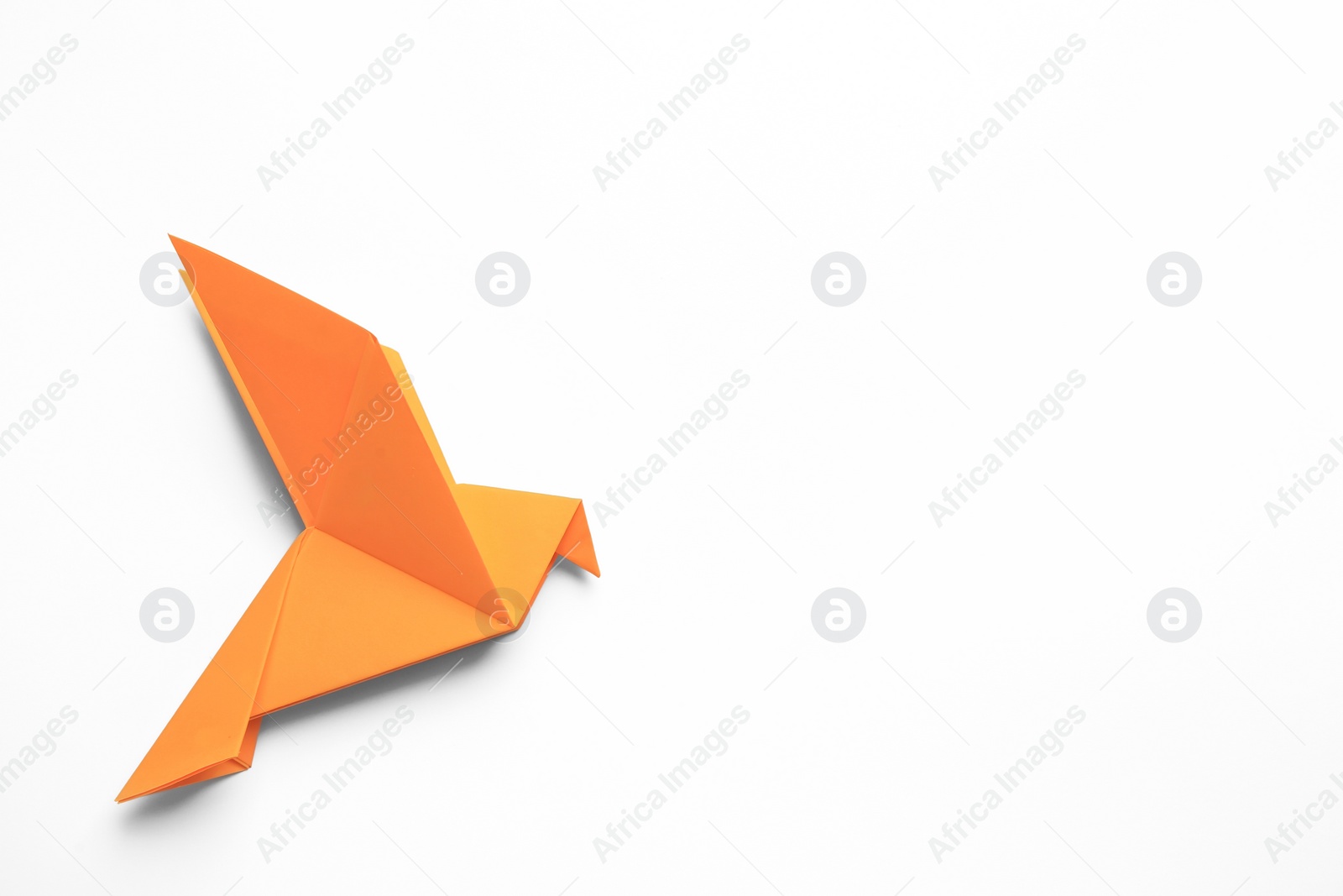 Photo of Beautiful orange origami bird on white background, top view. Space for text