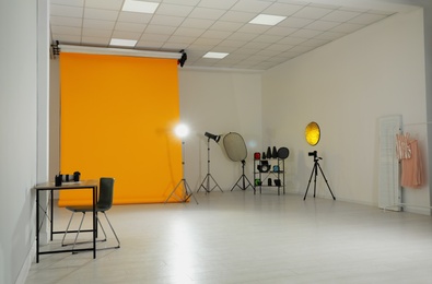 Photo studio interior with set of professional equipment and workplace