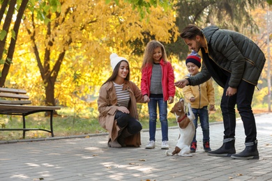 Photo of Happy family with children and dog in park. Autumn walk