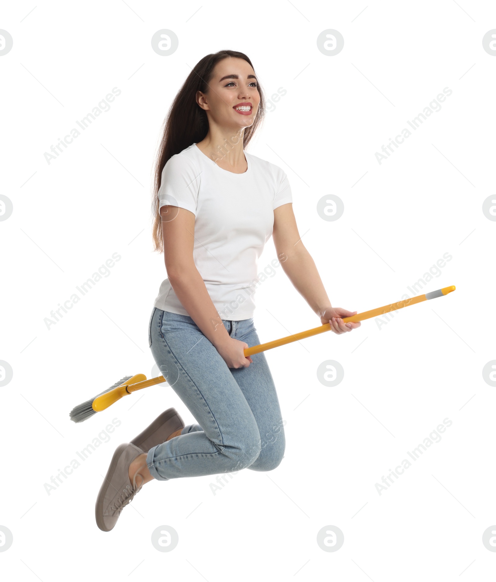 Photo of Beautiful young woman with broom jumping on white background