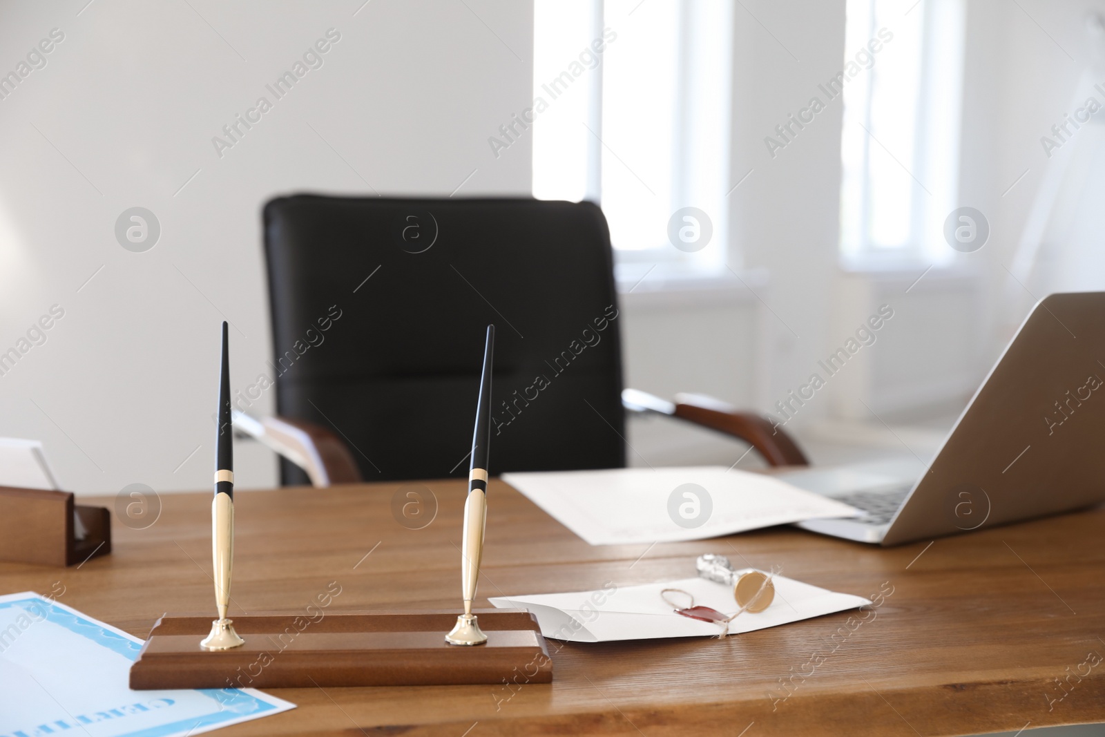 Photo of Wax stamp, documents and laptop on desk in notary's office