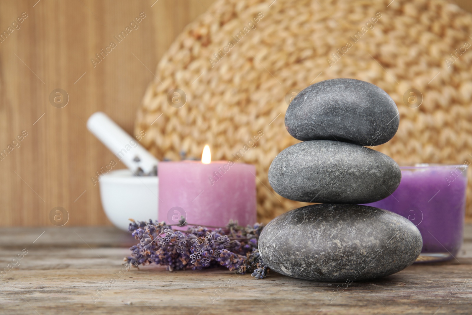 Photo of Spa stones with lavender flowers, candle and natural cosmetic on table