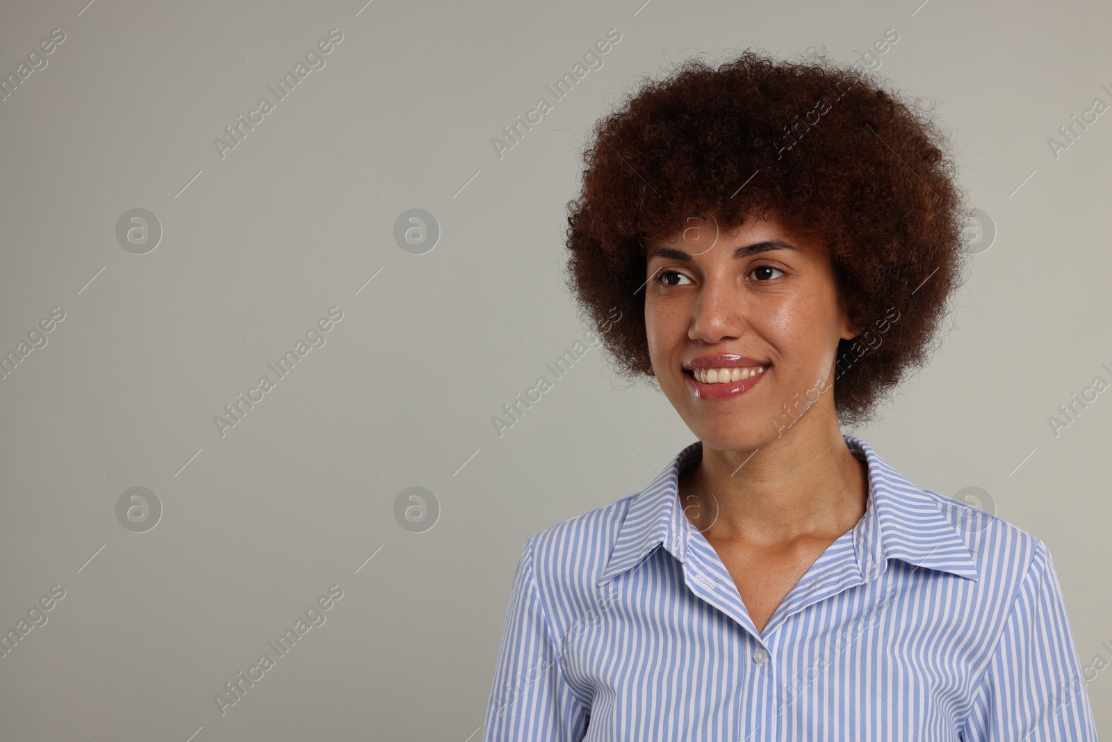 Photo of Portrait of happy young woman on grey background. Space for text