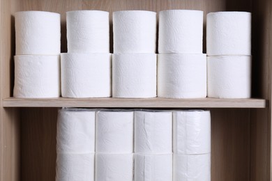 Photo of Stacked toilet paper rolls on wooden shelves