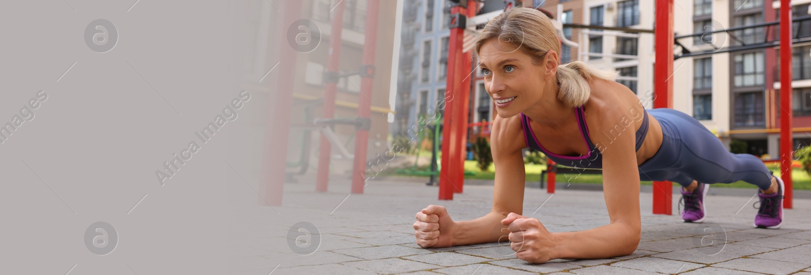 Image of Happy woman doing plank exercise at outdoor gym, space for text. Banner design