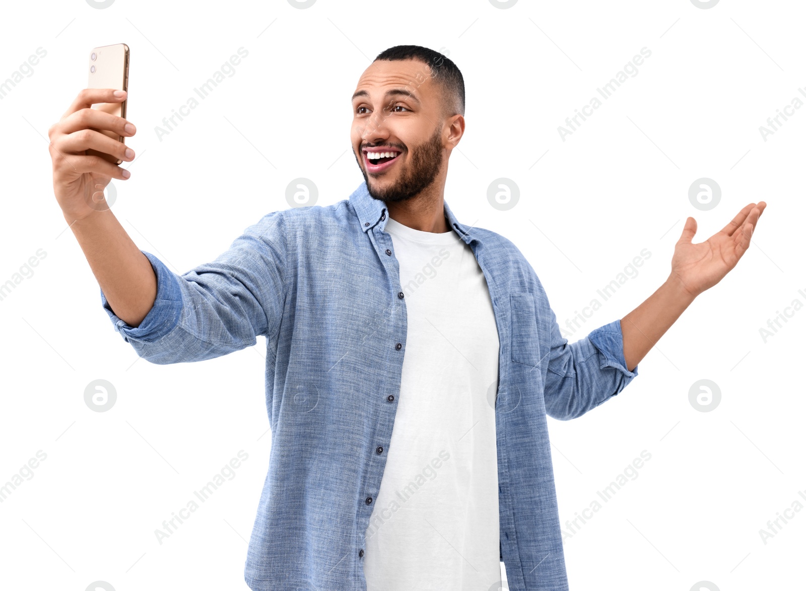 Photo of Smiling young man taking selfie with smartphone on white background