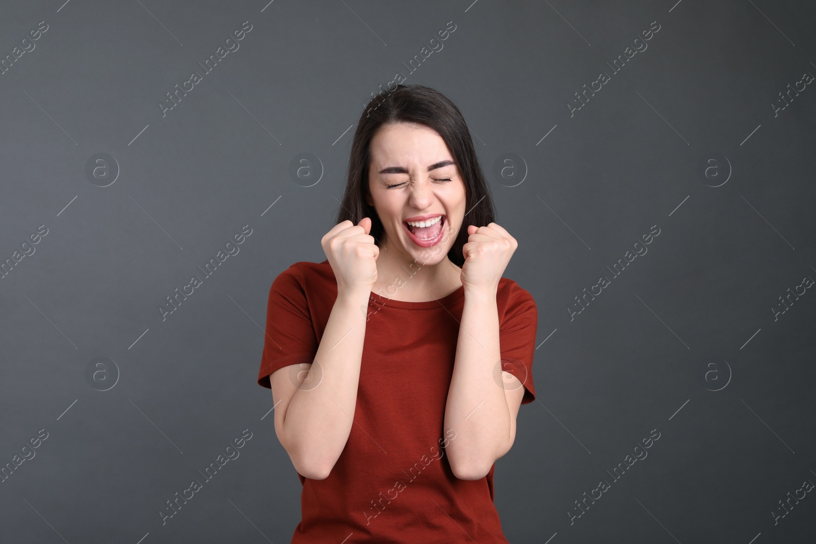 Photo of Portrait of happy young woman on dark grey background. Personality concept