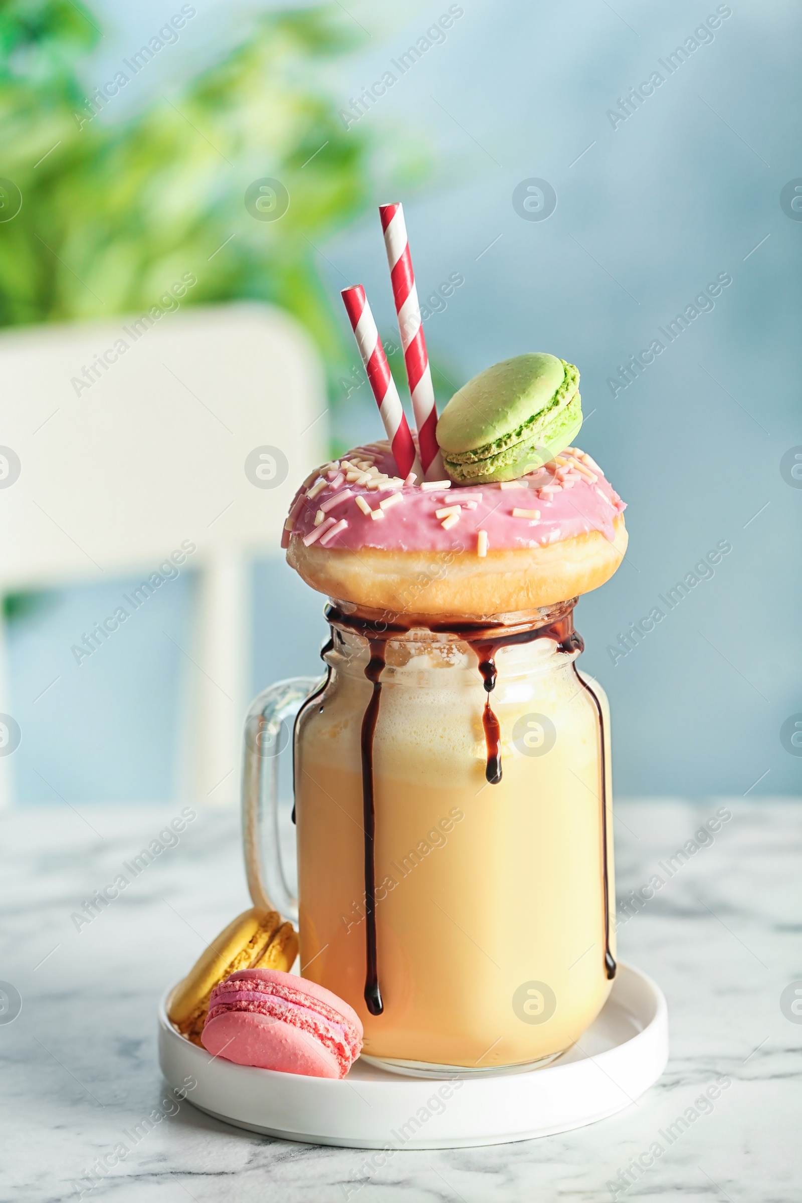 Photo of Mason jar with delicious milk shake on table against blurred background