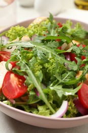 Photo of Delicious salad with chicken, arugula and tomatoes on table, closeup