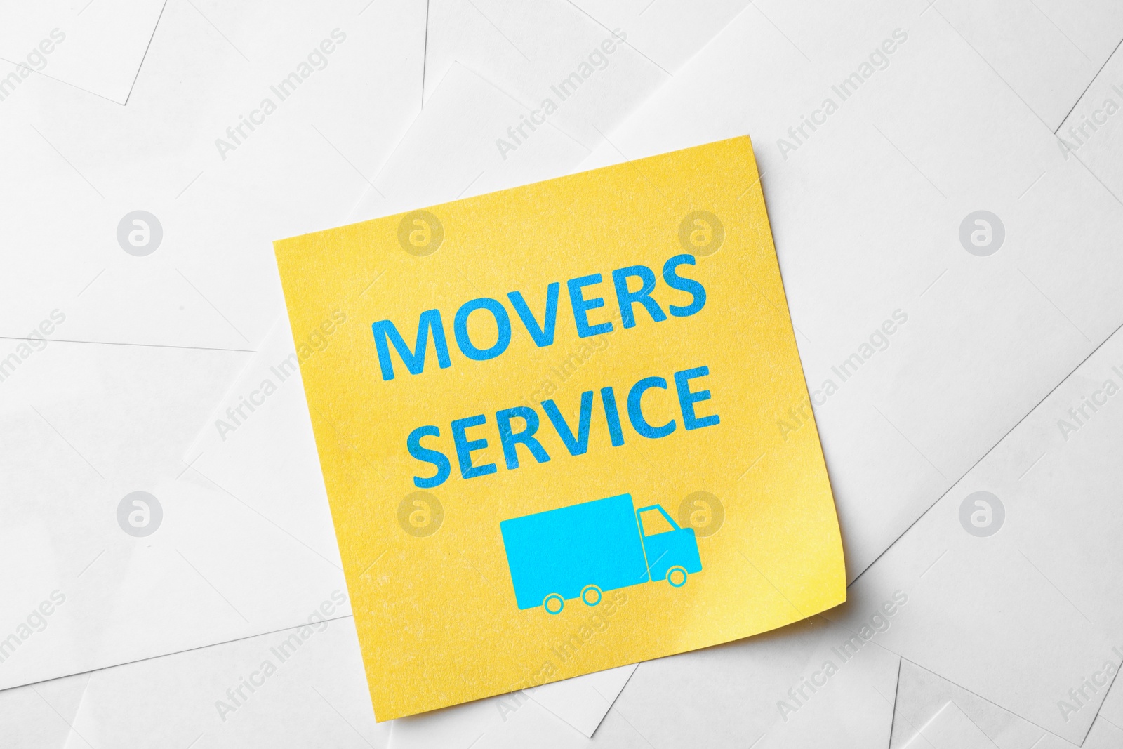 Image of Note with phrase MOVERS SERVICE on paper sheets, top view