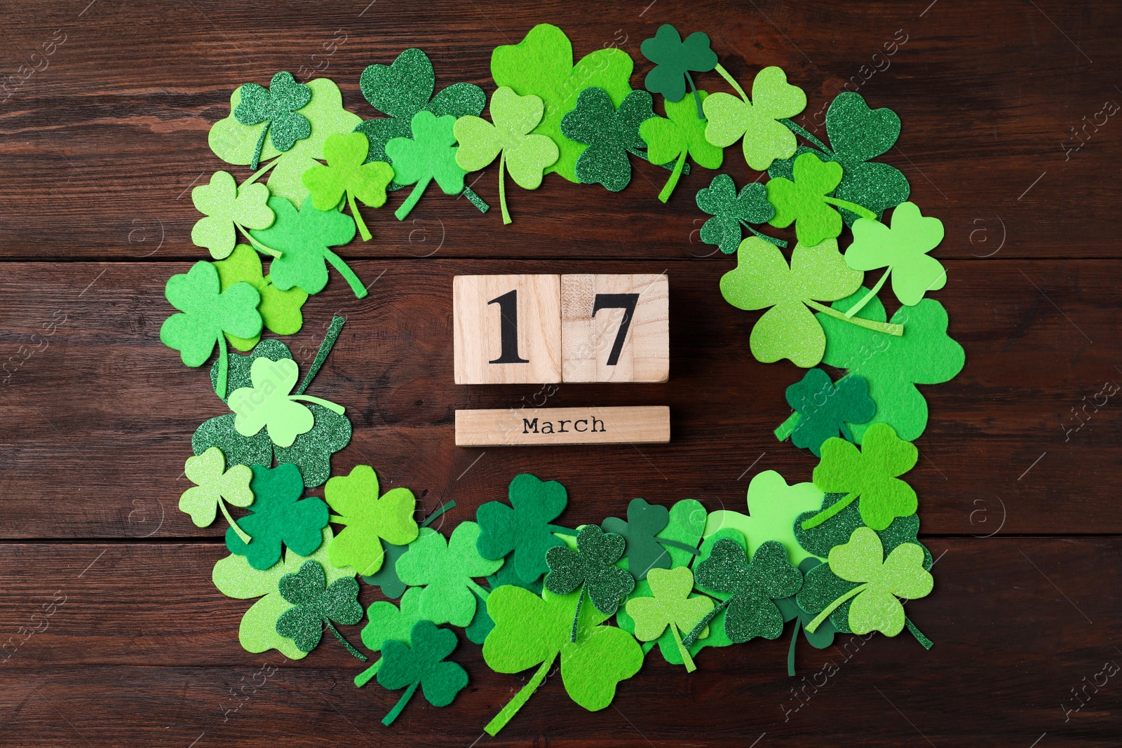 Photo of Flat lay composition with block calendar on wooden background. St. Patrick's Day celebration