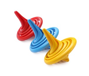 Photo of Three colorful spinning tops on white background