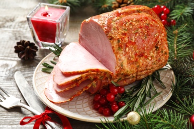 Plate with delicious ham served on wooden table. Christmas dinner
