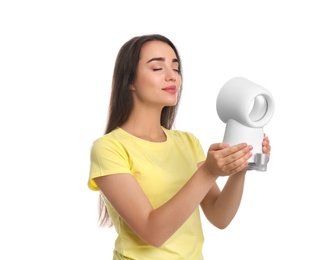 Photo of Woman enjoying air flow from portable fan on white background. Summer heat