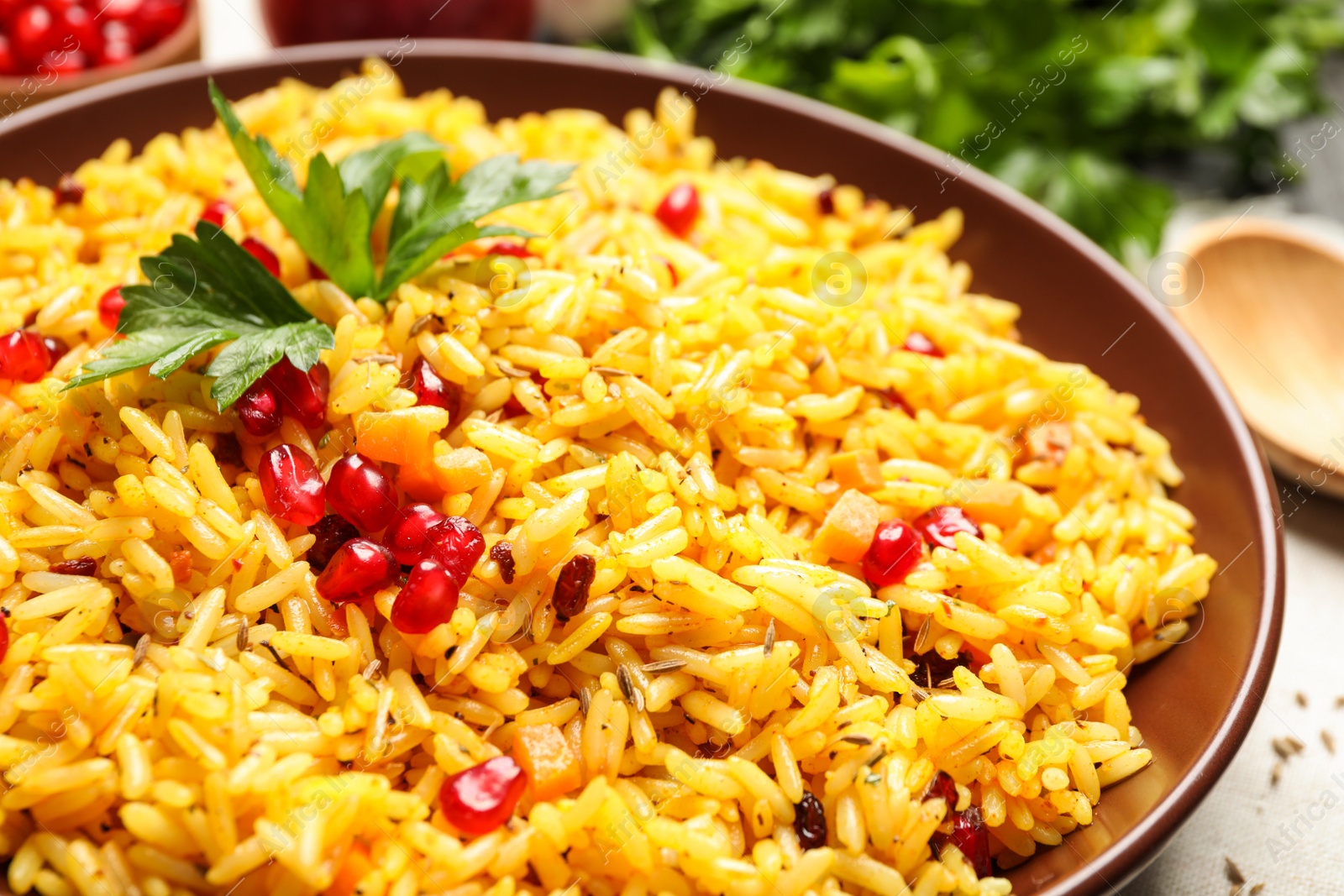 Photo of Tasty rice pilaf with pomegranate grains on table, closeup