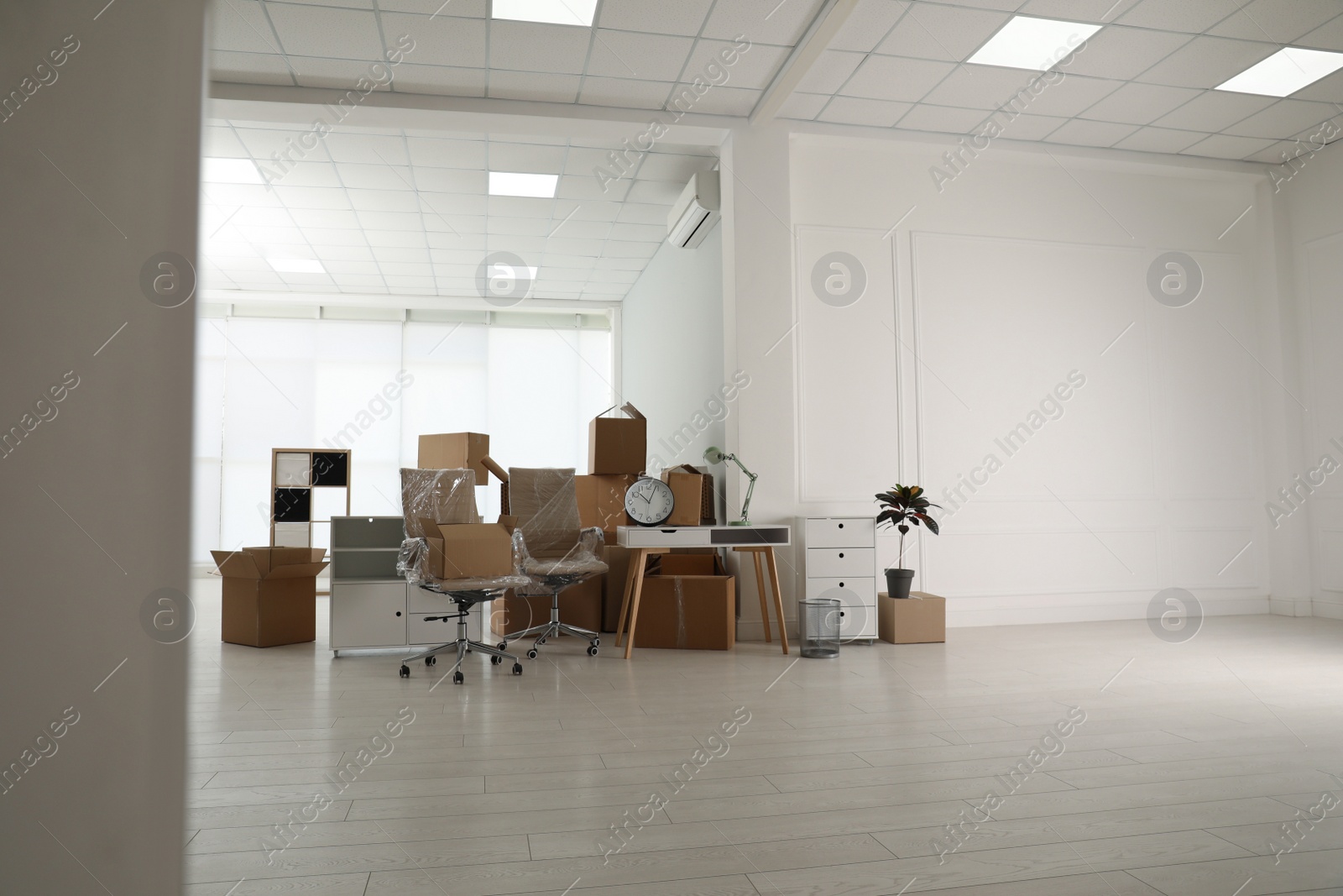 Photo of Cardboard boxes and packed stuff in office, space for text. Moving day