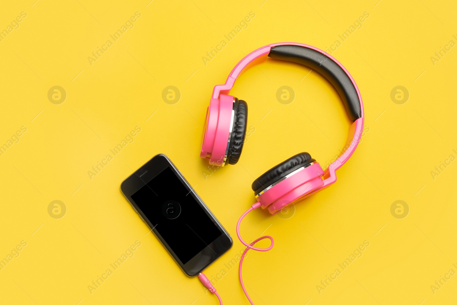 Photo of Stylish headphones and modern phone on color background, flat lay. Space for text