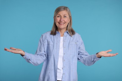 Photo of Portrait of happy surprised senior woman on light blue background