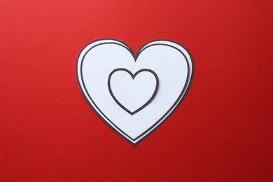 Photo of Paper hearts on red background, top view