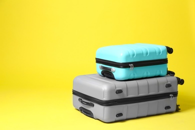 Stylish suitcases on yellow background. Space for text