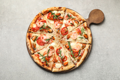 Delicious seafood pizza on light grey table, top view