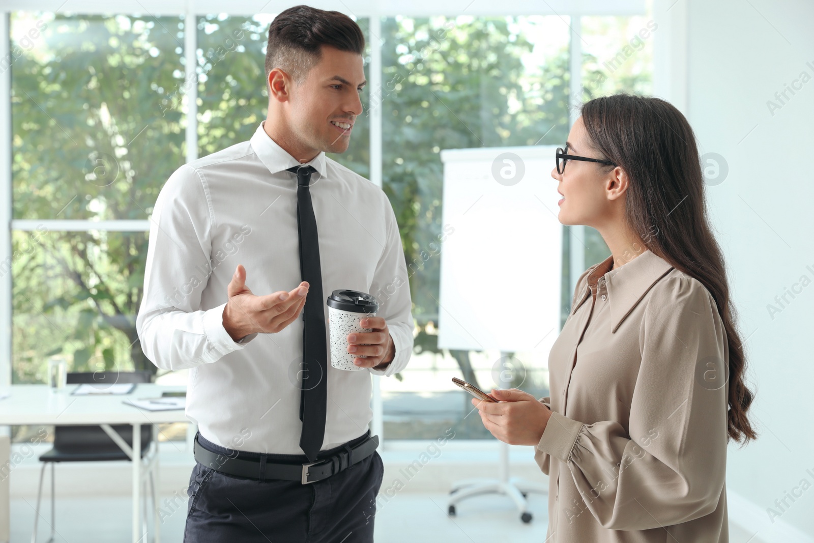 Photo of Office employees talking at workplace during break