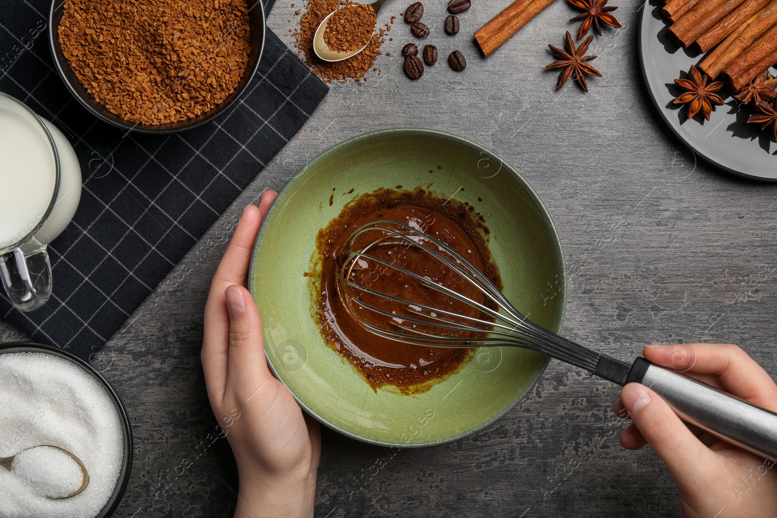 Photo of Woman whipping cream for dalgona coffee at gray table, top view