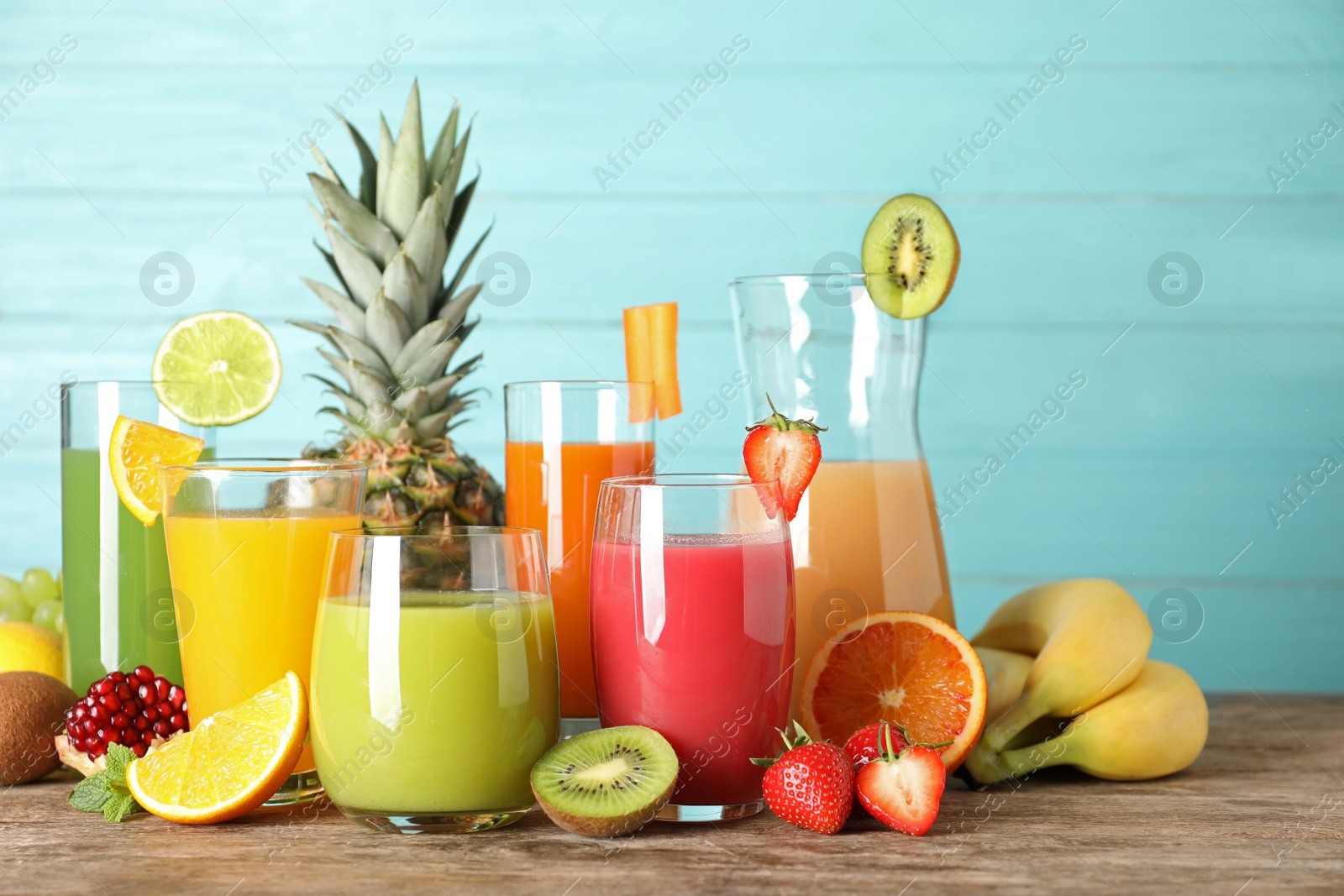 Photo of Glassware with different juices and fresh fruits on table