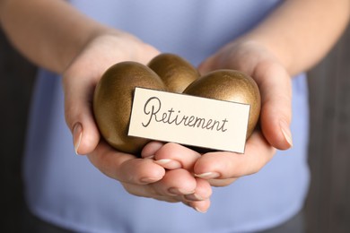 Photo of Woman holding golden eggs and card with word Retirement, closeup. Pension concept