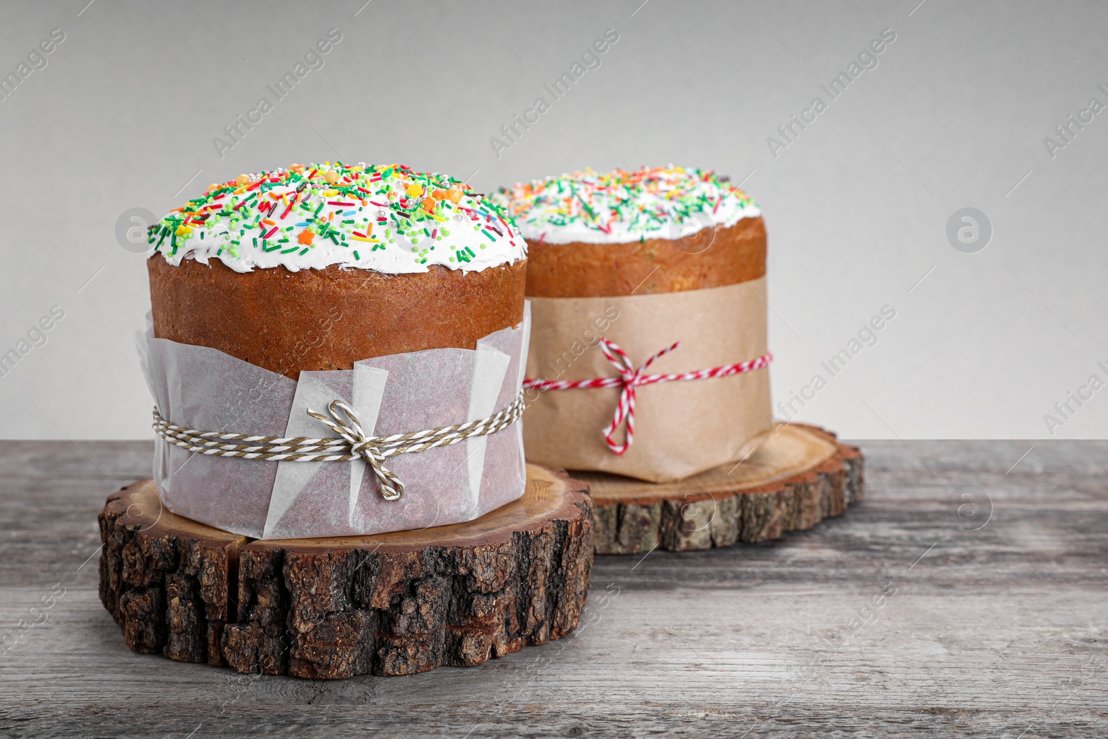 Photo of Traditional Easter cakes with sprinkles on wooden table, space for text