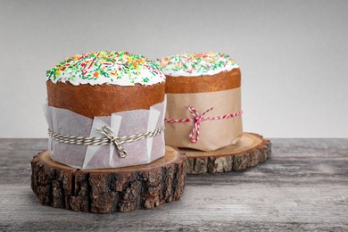 Photo of Traditional Easter cakes with sprinkles on wooden table, space for text
