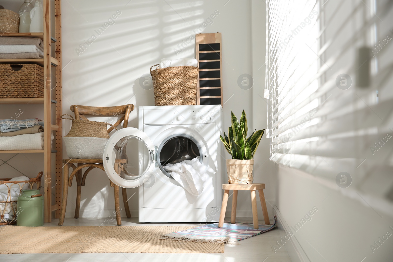 Photo of Modern washing machine in laundry room interior