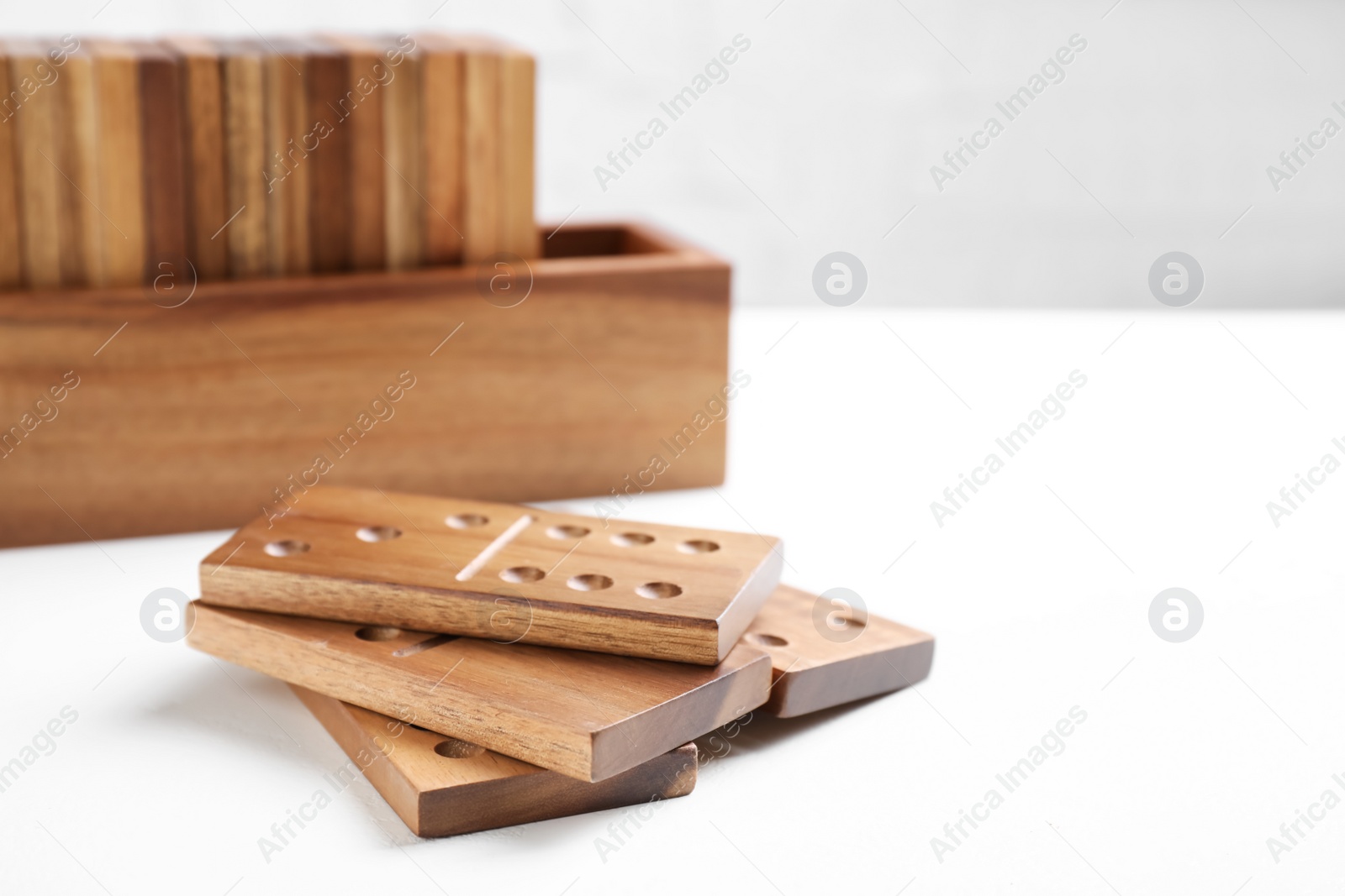 Photo of Beautiful wooden dominoes tiles on white table