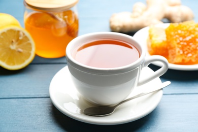 Photo of Tea with honey and lemon on blue wooden table