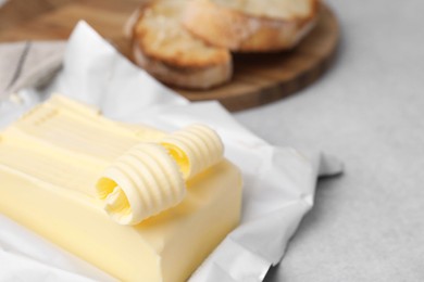 Photo of Tasty butter and curls on light grey table, closeup