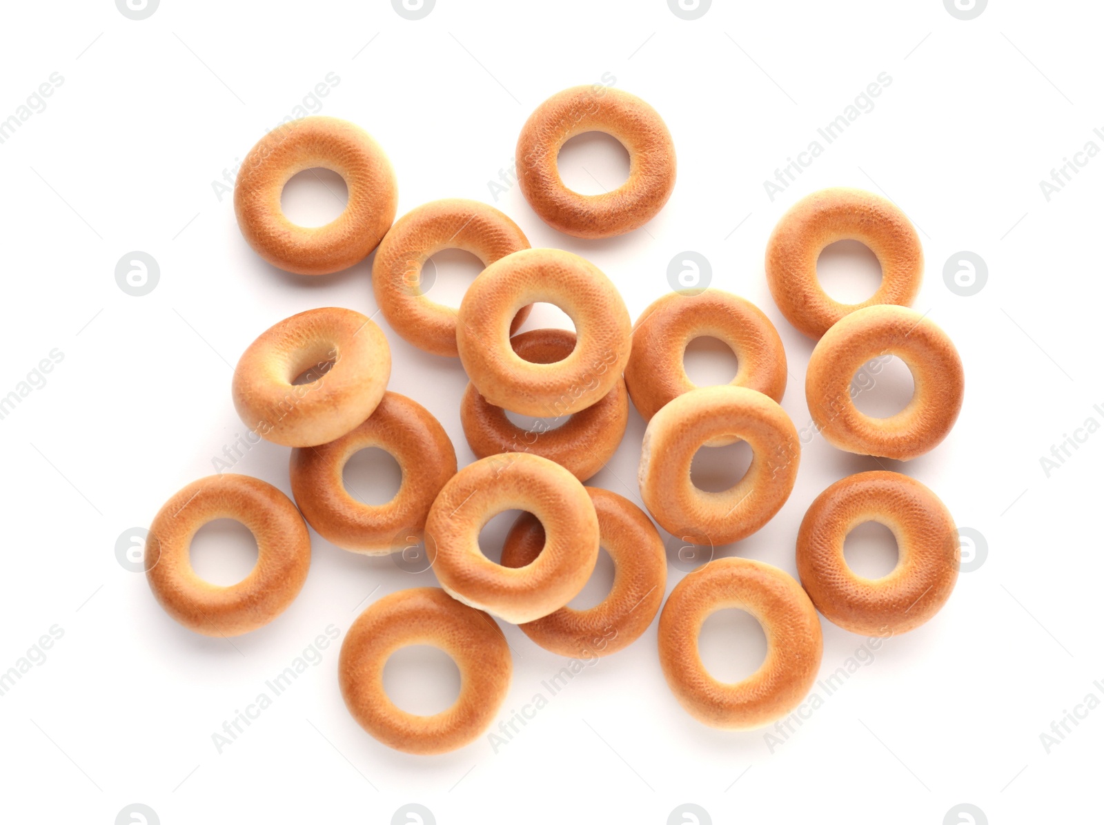 Photo of Many tasty dry bagels (sushki) isolated on white, top view