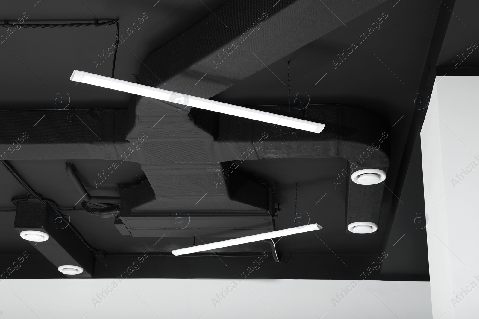 Photo of Black ceiling with modern lighting in room, low angle view