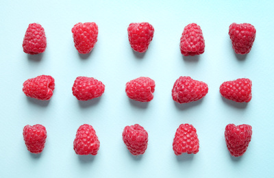 Photo of Flat lay composition with delicious ripe raspberries on light blue background